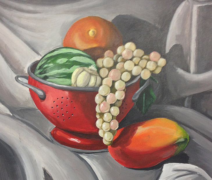 Color and form study of a red colander with watermelon, garlic, grapes, and a mango on draped fabric