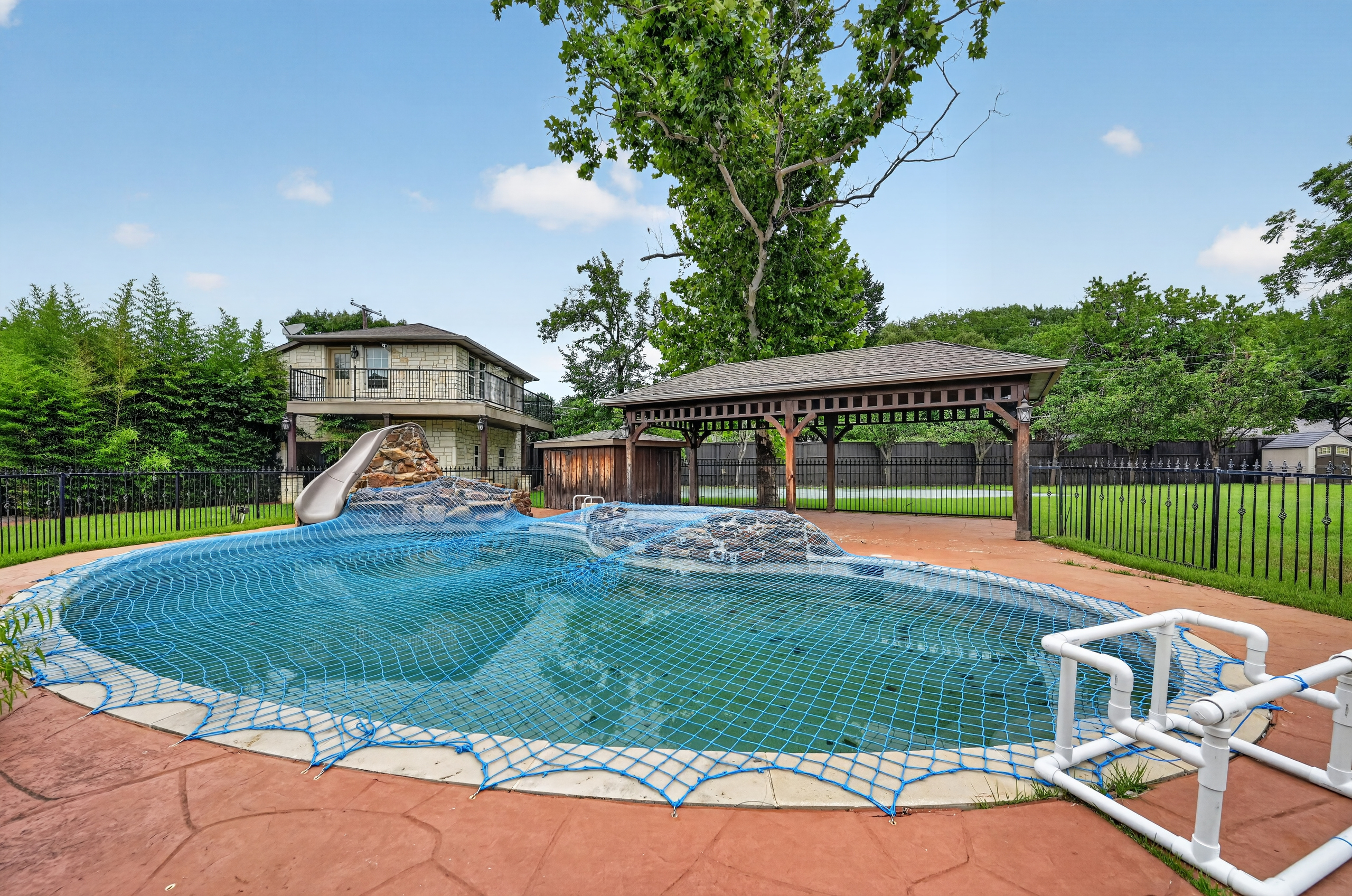 Pool with water slide, rock waterfall, pavilion, and guest house