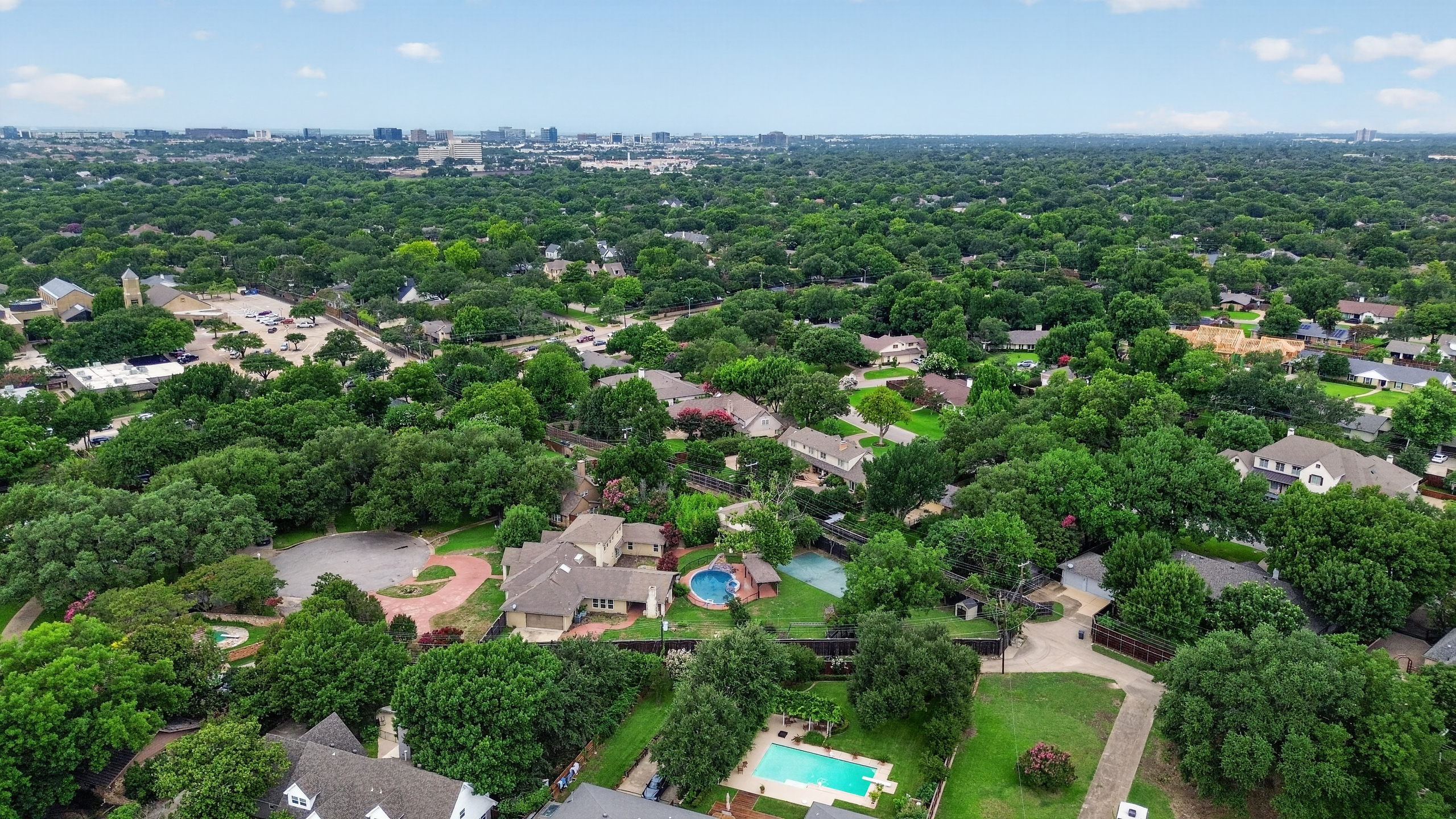 High-angle aerial capture overlooking private cul-de-sac and skyline in the distance
