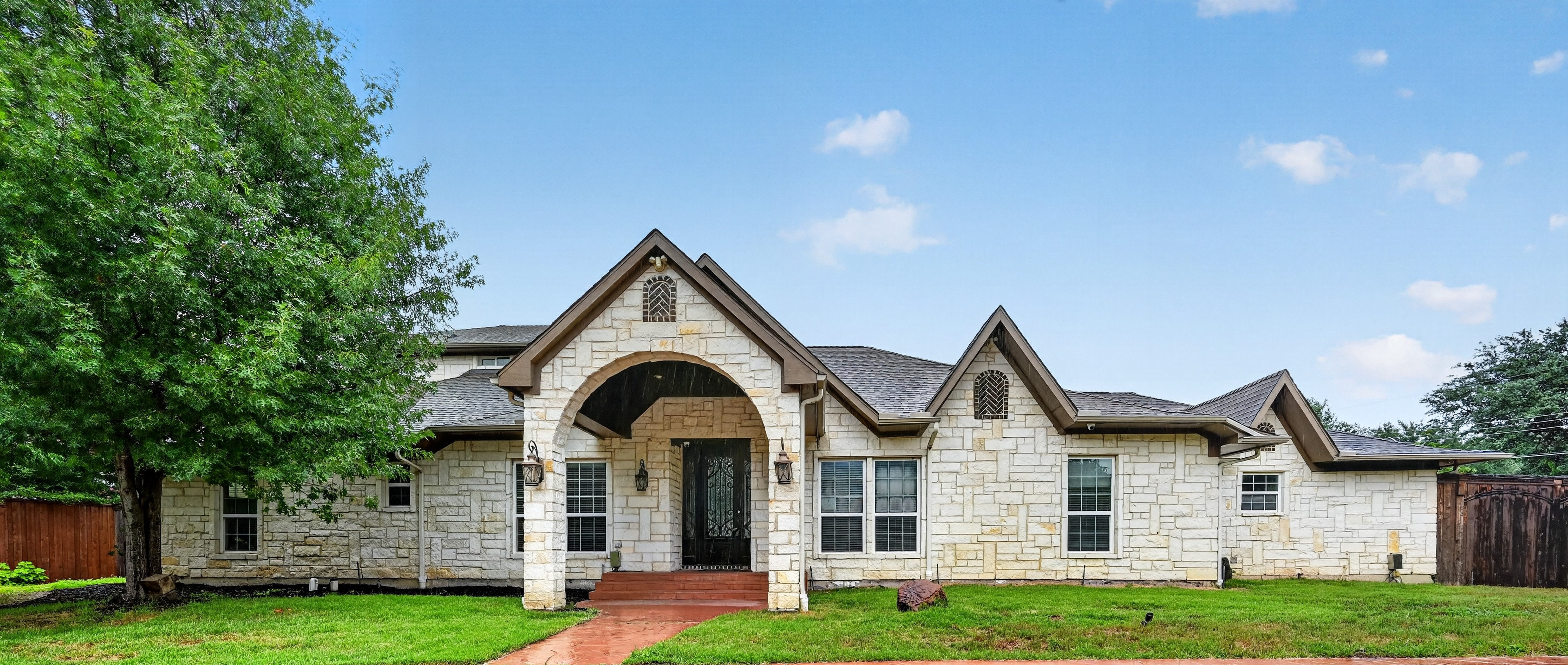 Front elevation showcasing custom multi-gabled roofline and landscaped lawn