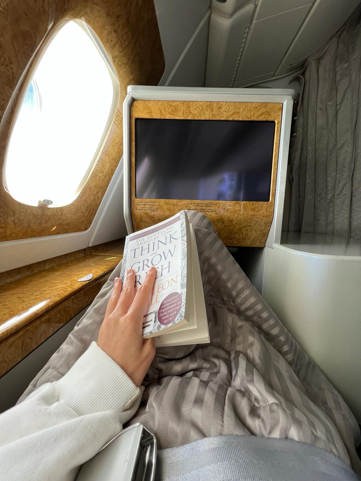 Liegesitz mit Buch und Decke in der Business Class