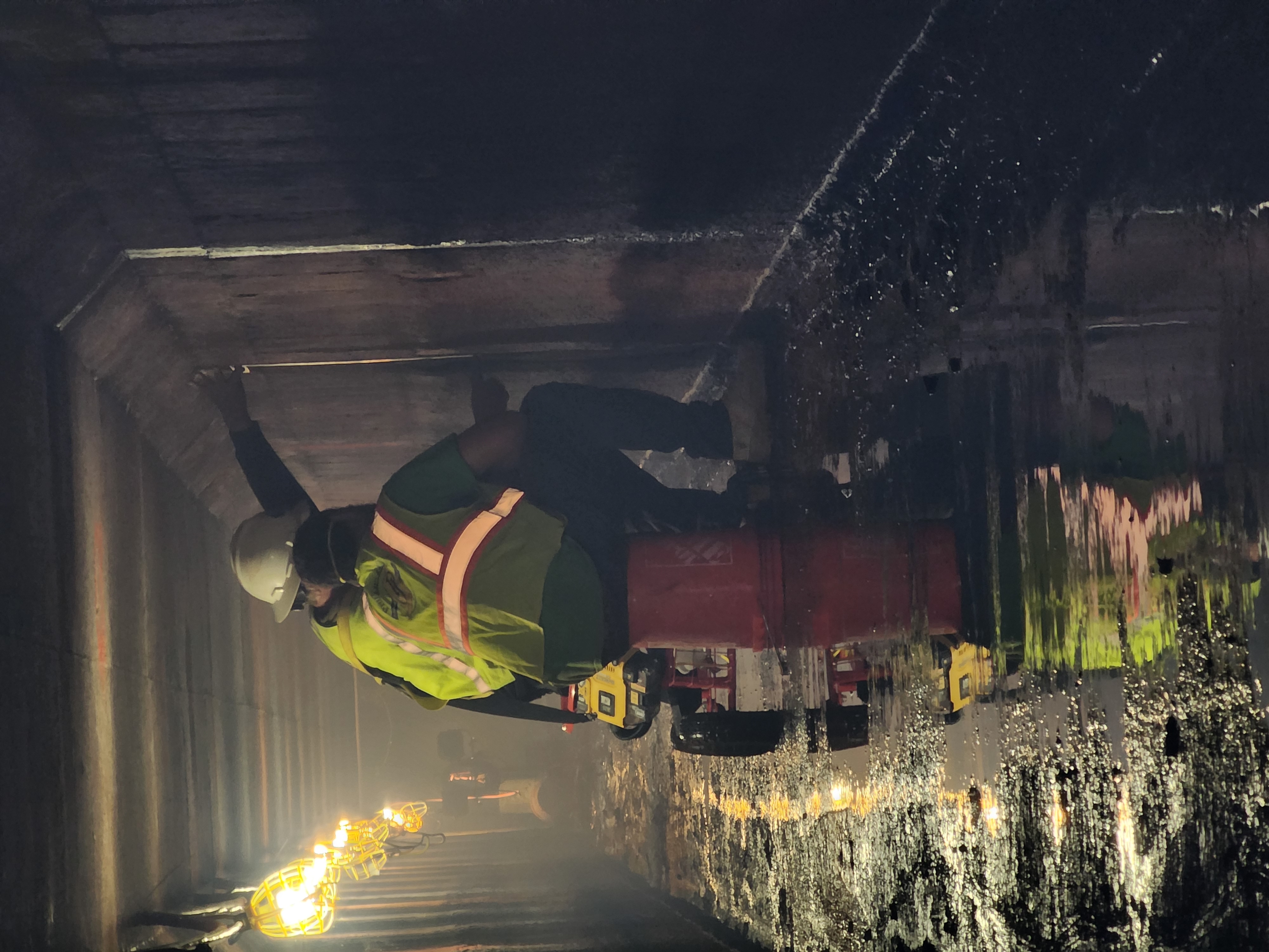 Personal técnico realizando inspección en túnel y galería hidráulica de concreto