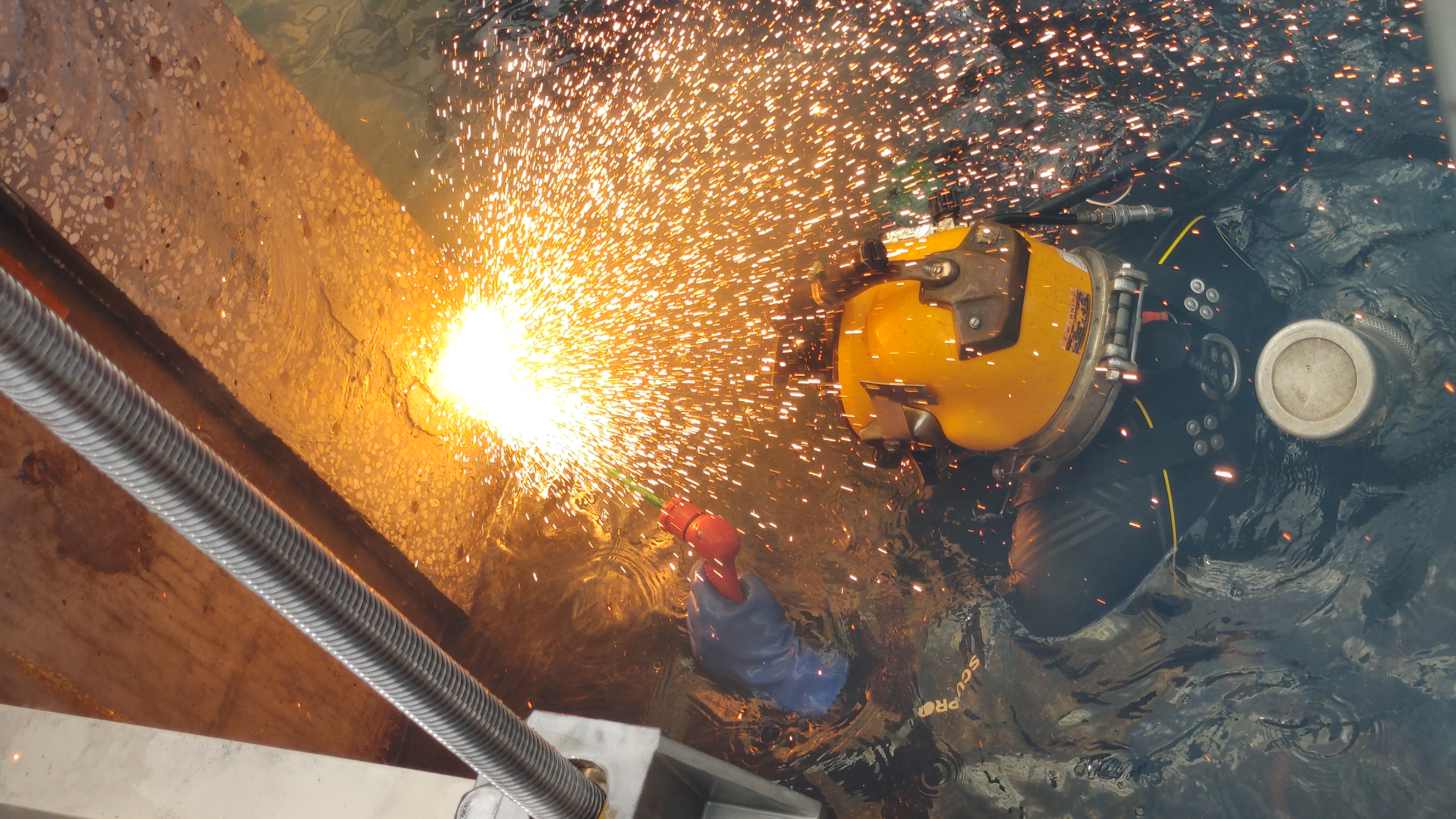 Buzo comercial realizando corte y soldadura subacuática con arco exotérmico