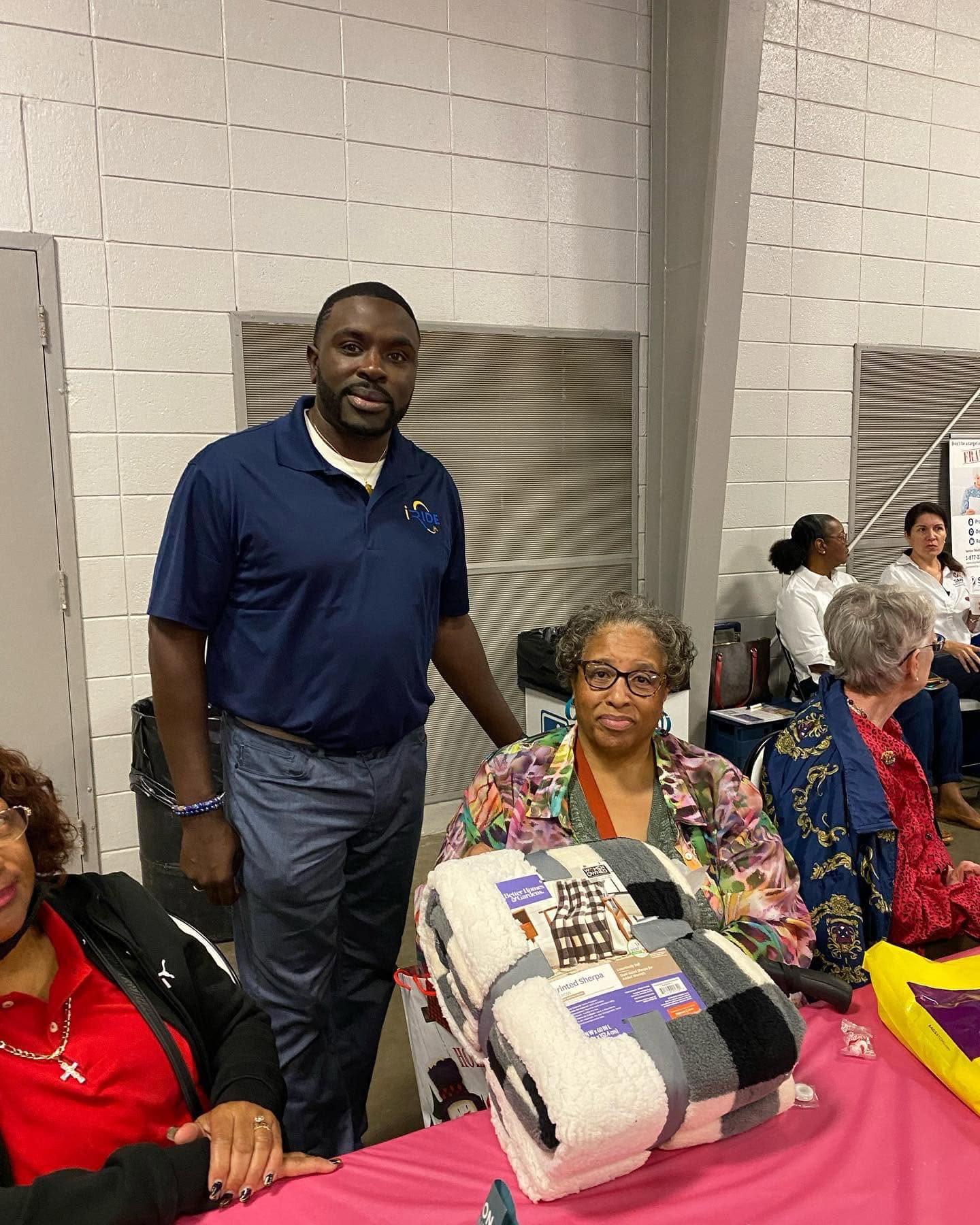 Cleveland Auzenne at a community gift giveaway with cozy sherpa blankets.
