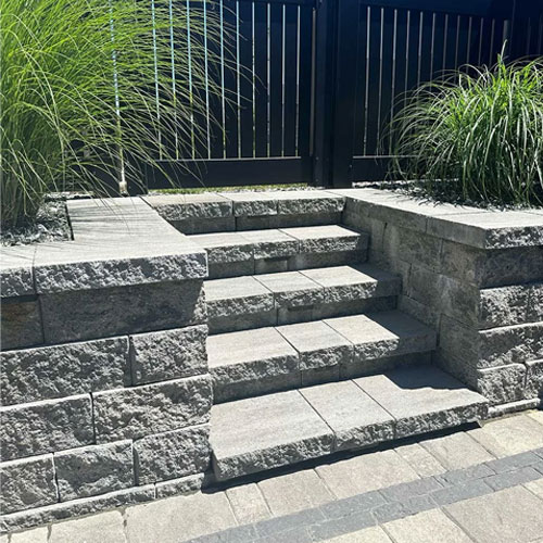 Stone block steps with ornamental grasses by IVE Landscaping