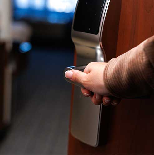 Guest unlocking a hotel room door with key card