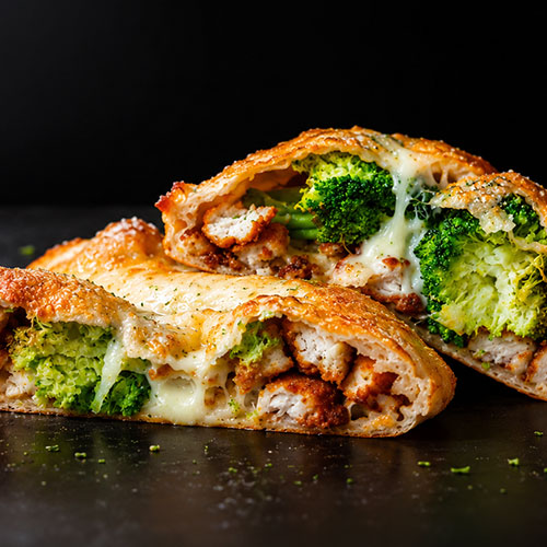 Food photography of a chicken and broccoli calzone