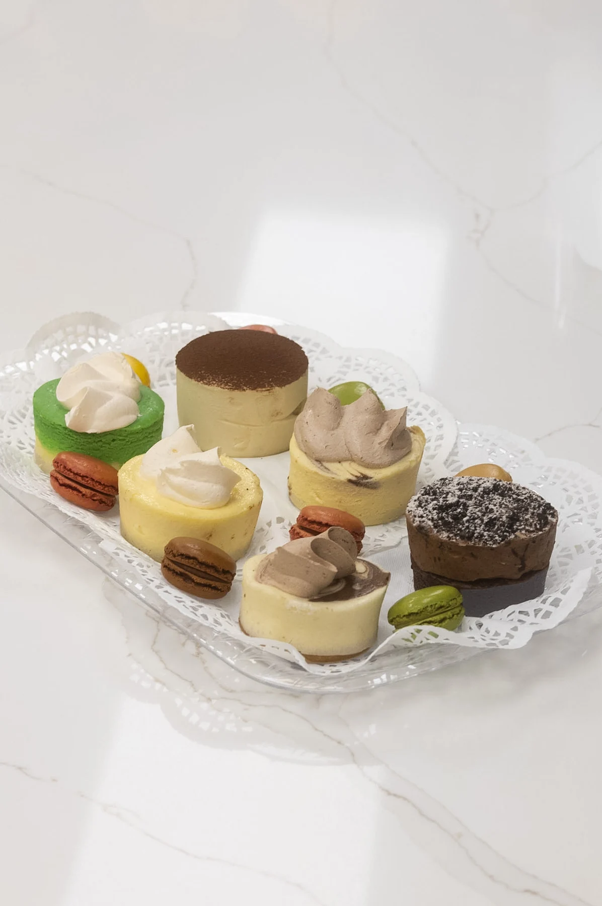 A selection of petite cakes, cream toppings, and macarons