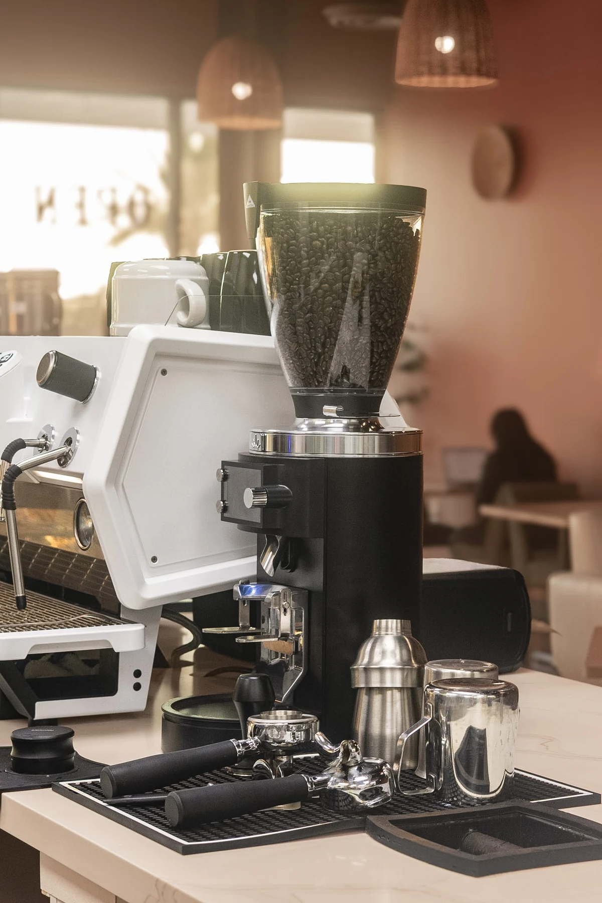 Elura's espresso machine, coffee grinder, and barista tools in the warm café light