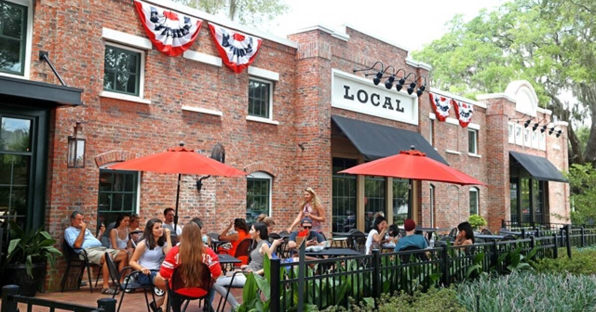 Downtown Winter Garden outdoor patio dining with red umbrellas along historic brick building
