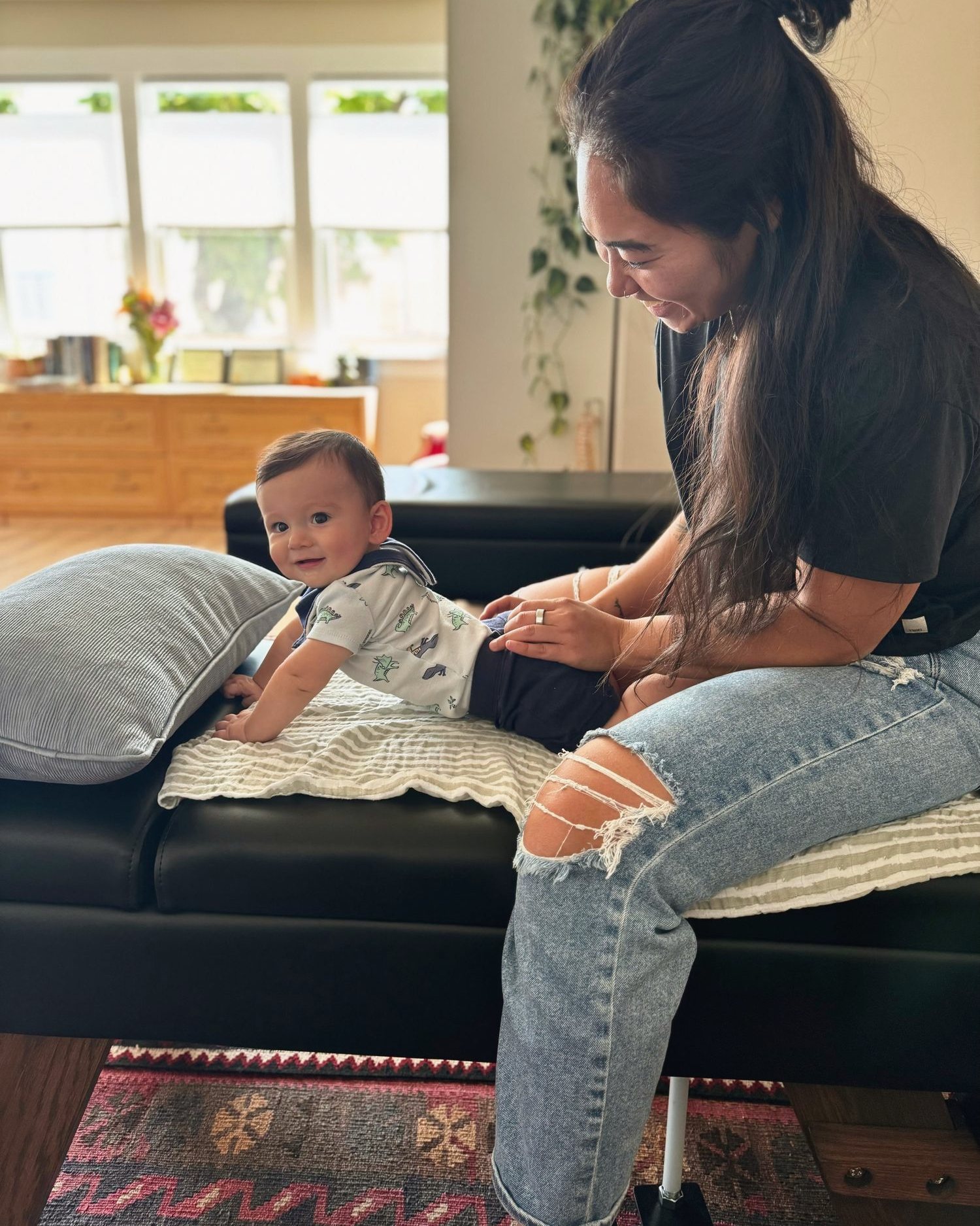 Dr. Kaitlyn Shikada smiling down at a happy baby during a gentle visit in the sunlit clinic