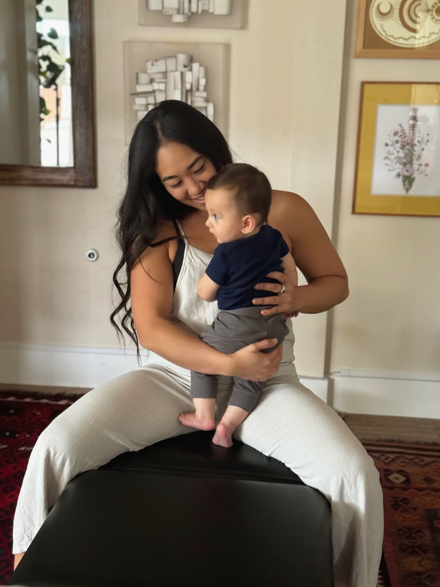 Dr. Kaitlyn Shikada cuddling a smiling baby on her lap