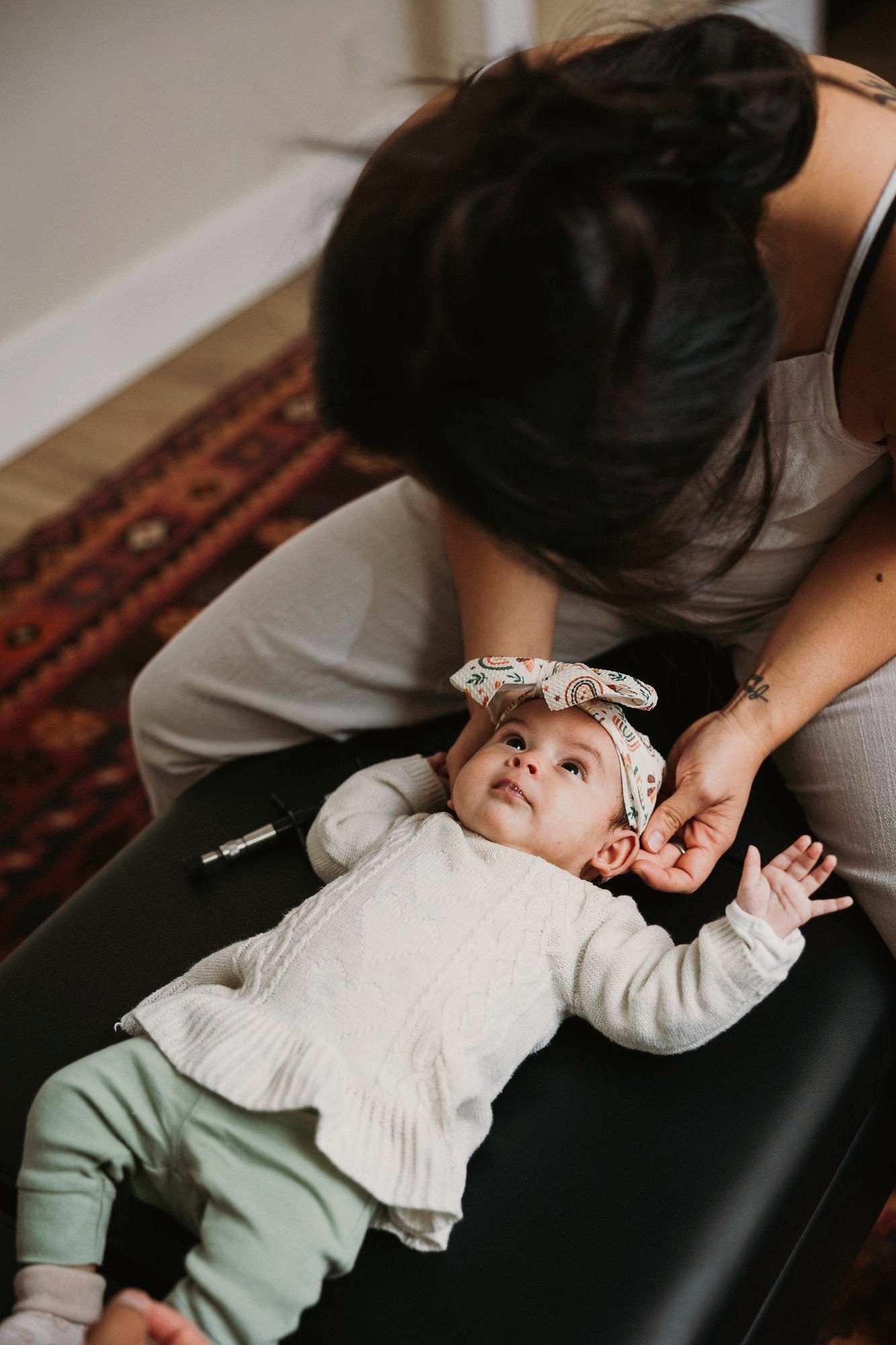 Dr. Kaitlyn Shikada gently caring for a newborn wearing a floral headband