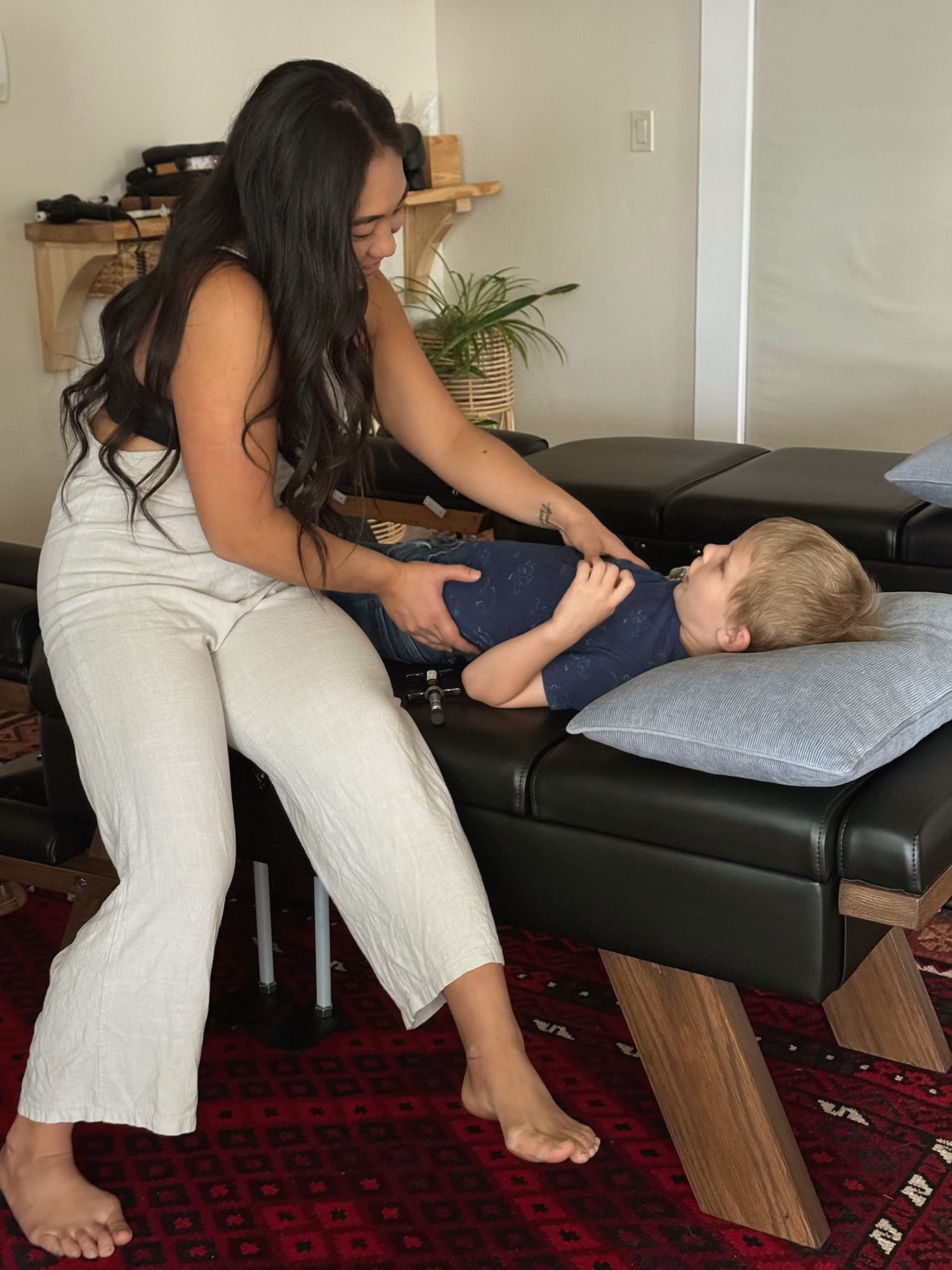 Dr. Kaitlyn Shikada giving a gentle adjustment to a young child on the table