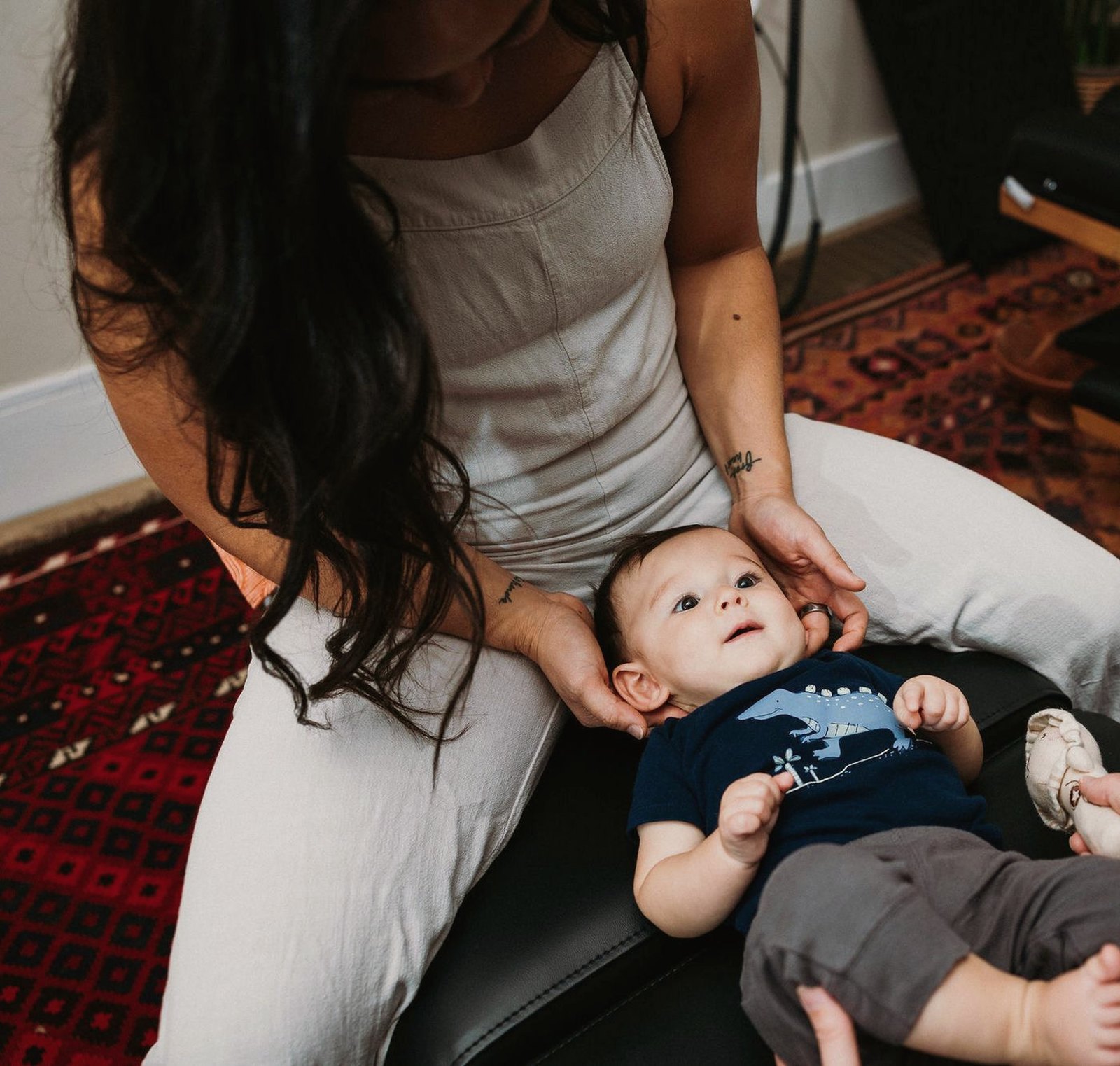 Dr. Kaitlyn Shikada gently cradling a baby's head while a parent stays close