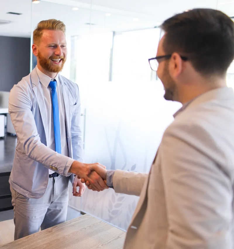 Mortgage professional shaking hands with partner in office