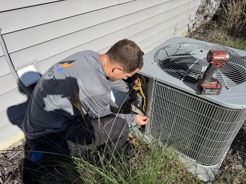 Mike Abbott servicing outdoor air conditioning unit and electrical components