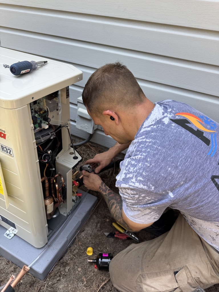 Mike Abbott connecting line set on outdoor Amana heat pump during HVAC service in Southern Pines, NC