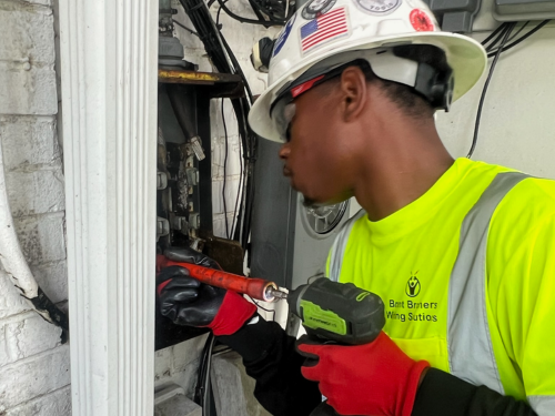 Electrician diagnosing a breaker panel with a multimeter in Chesterfield, VA