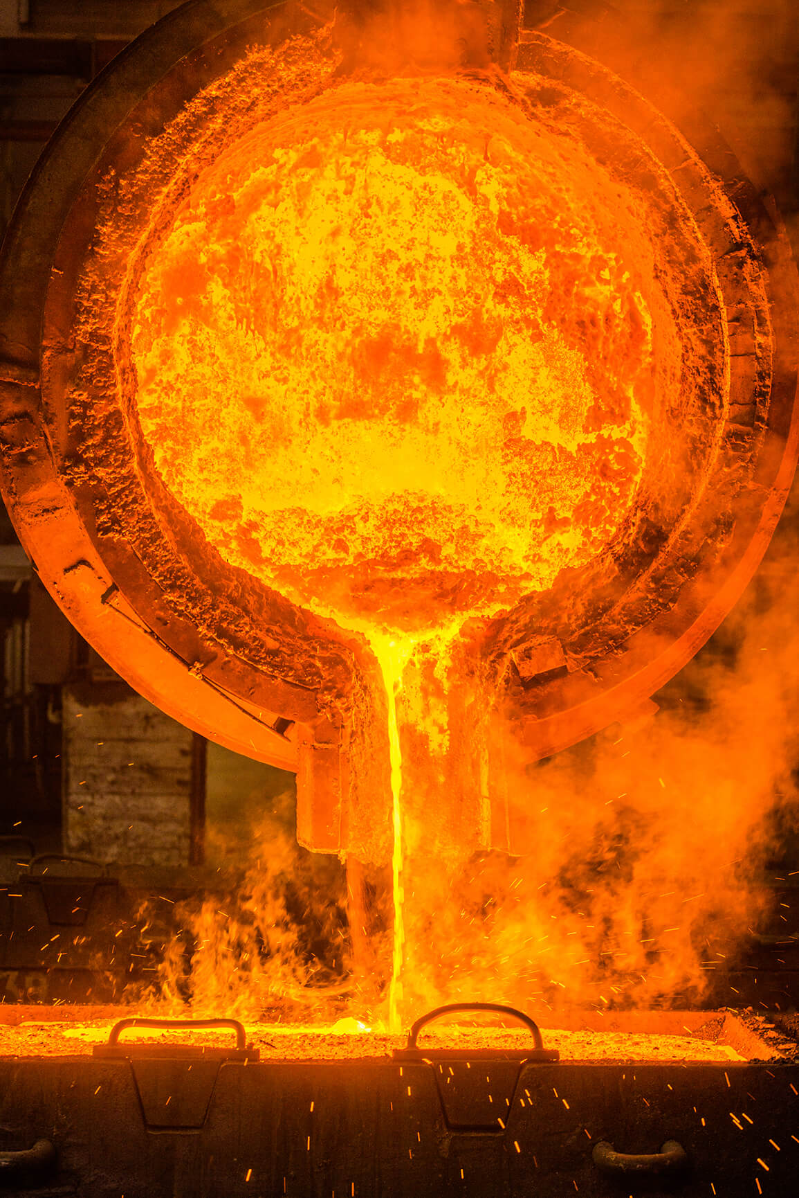 Colada de metal líquido incandescente en caldera industrial y control del calor