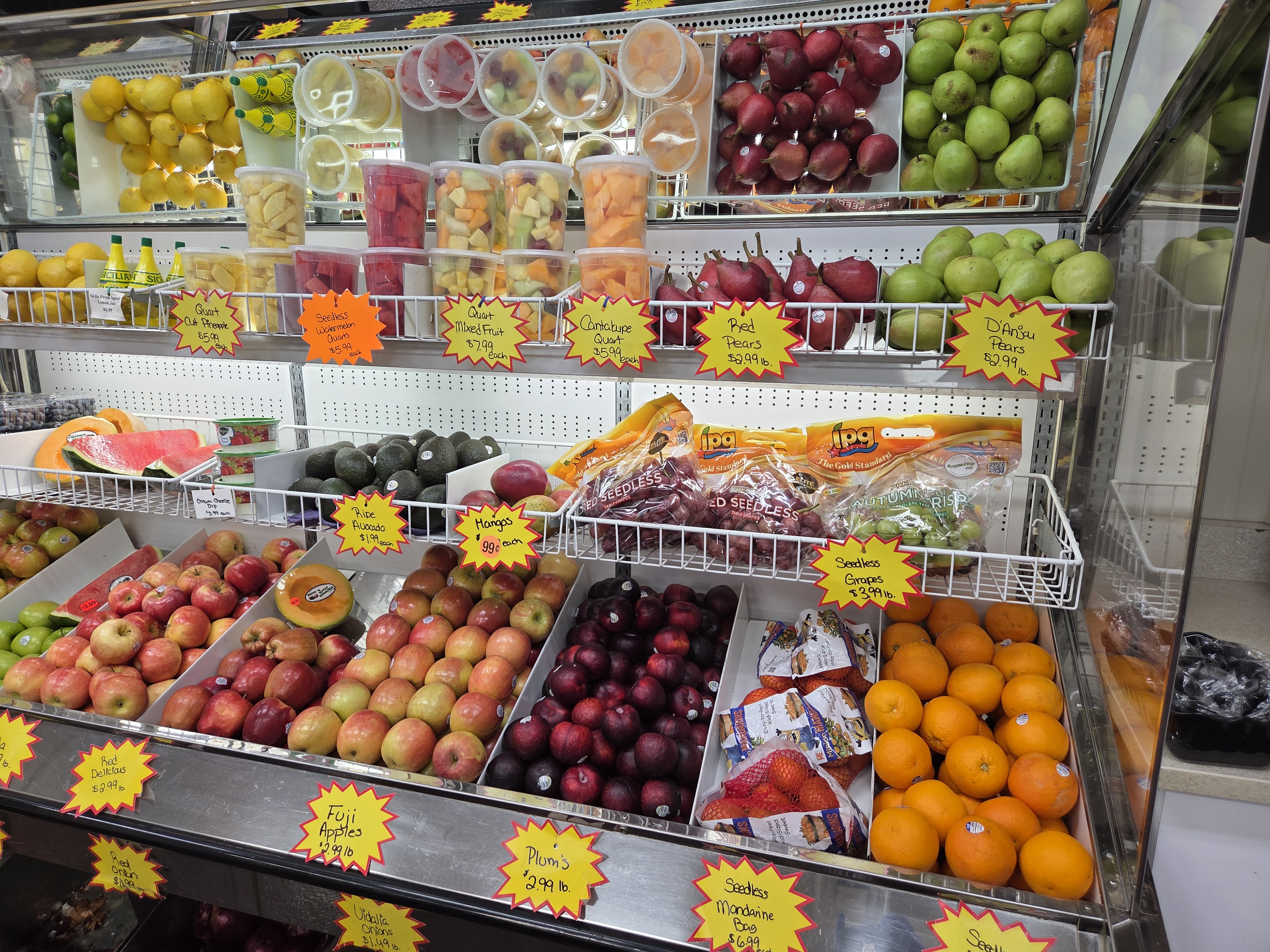 Fresh orchard fruit display with apples, pears, and cut fruit cups at Sap's