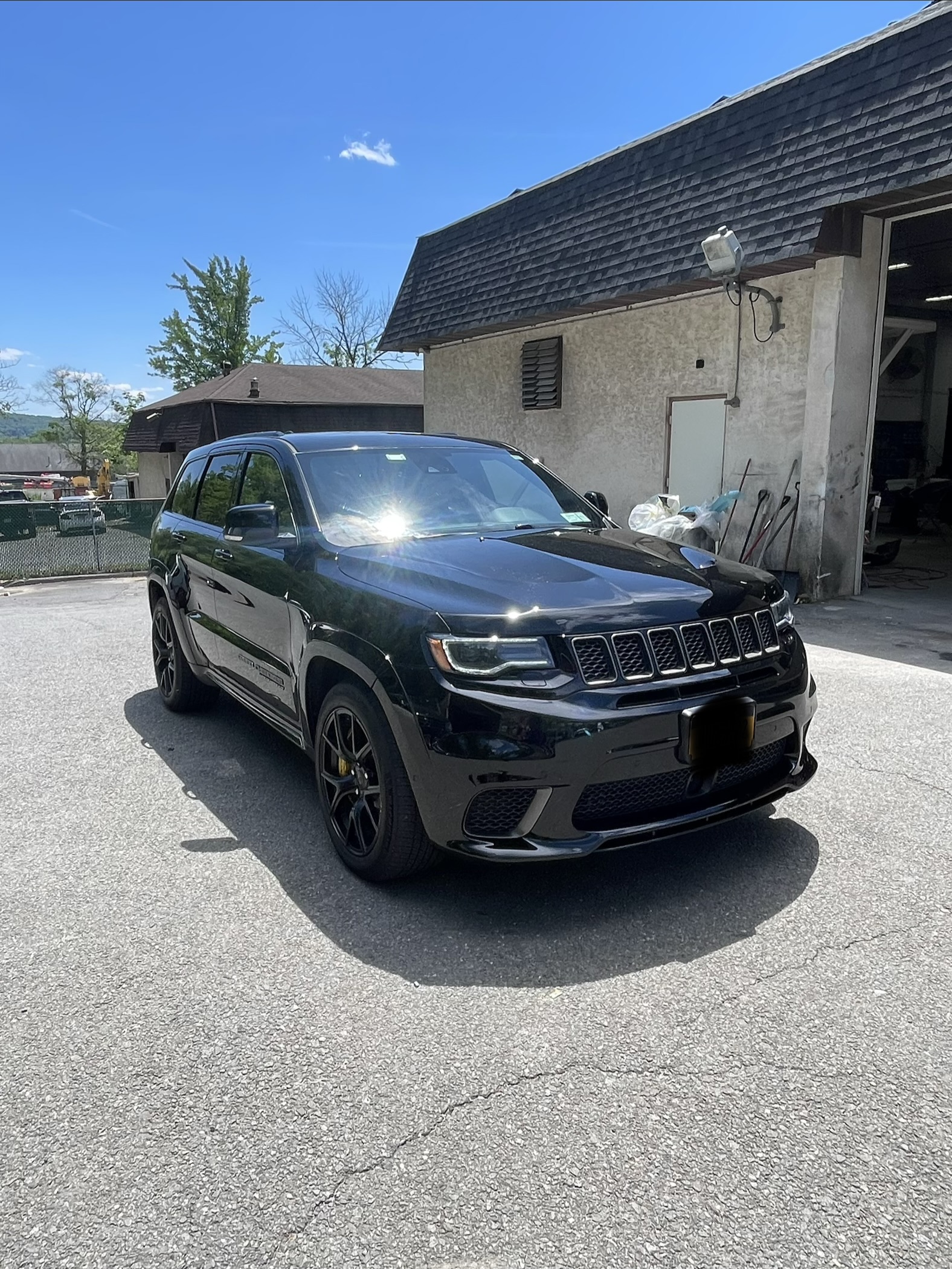 Black Jeep Grand Cherokee SRT gloss body and paint finish outside Greg Zurla's Auto Body, Congers, NY