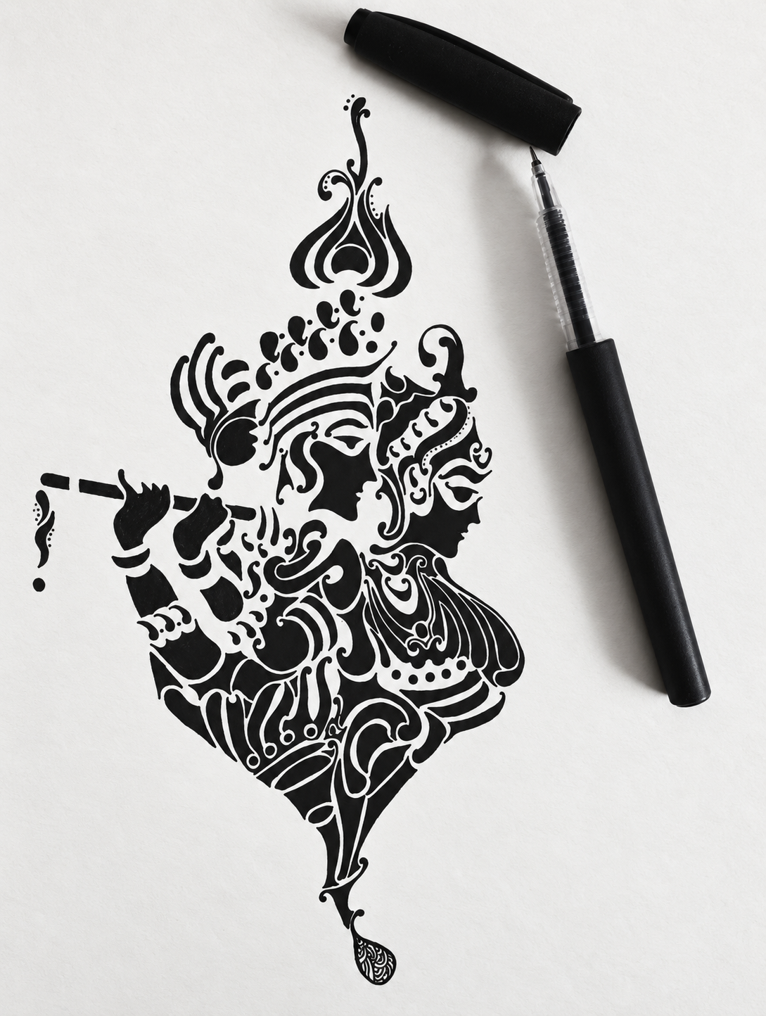 Intricate monochrome artwork by Chahat Gandhi, photographed beside a black pen.
