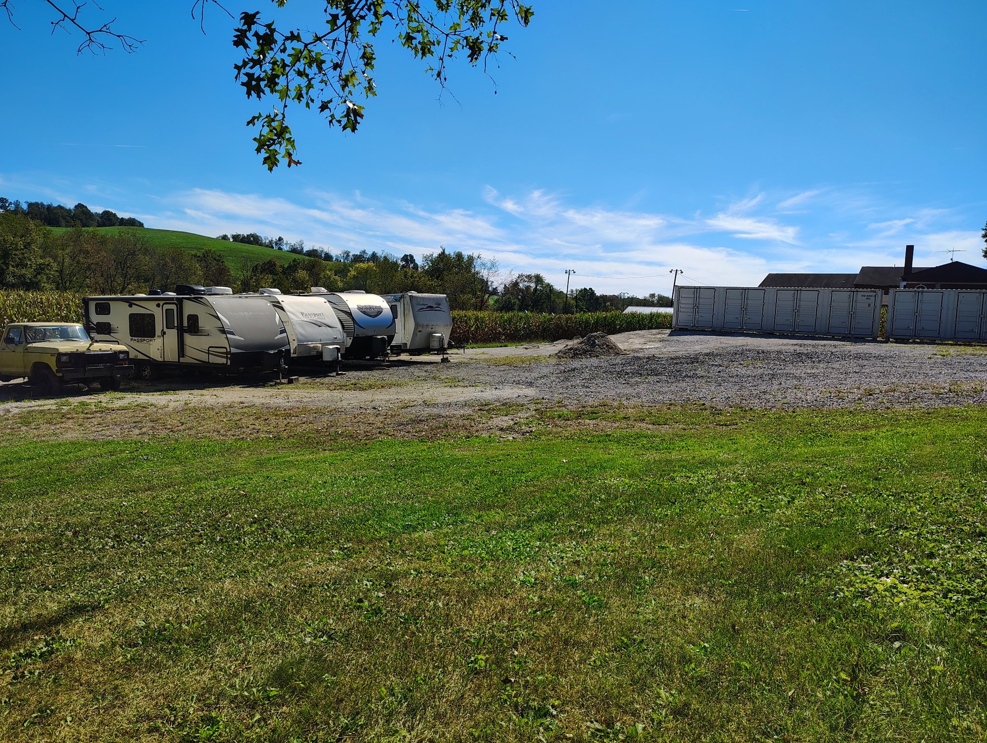 Outdoor gravel storage area at Ragersville Storage LLC showing parked campers, storage units, and rural countryside hills
