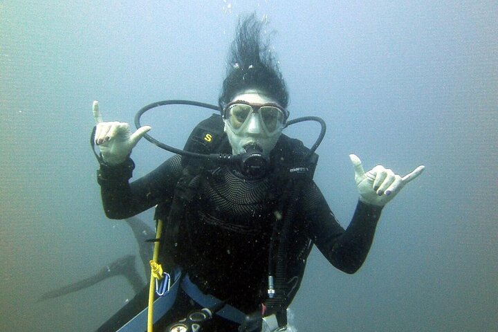 Diver giving a shaka sign underwater in Lake Ilopango