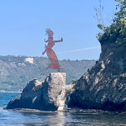 Sculpted dancer monument perched on a rocky island at Lake Ilopango