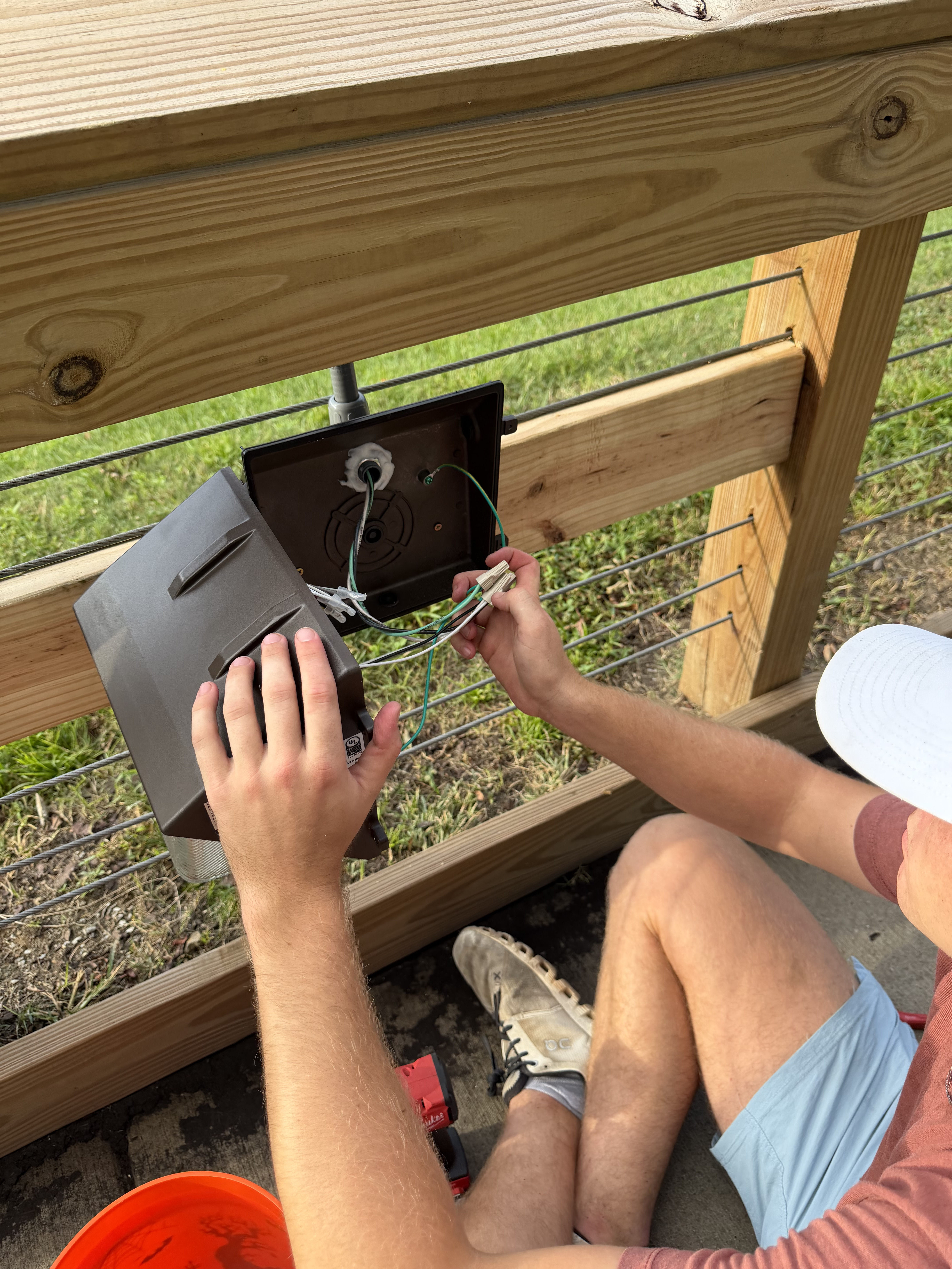 Cole Nelson connecting exterior weatherproof pathway fixture wiring by hand with wire nuts