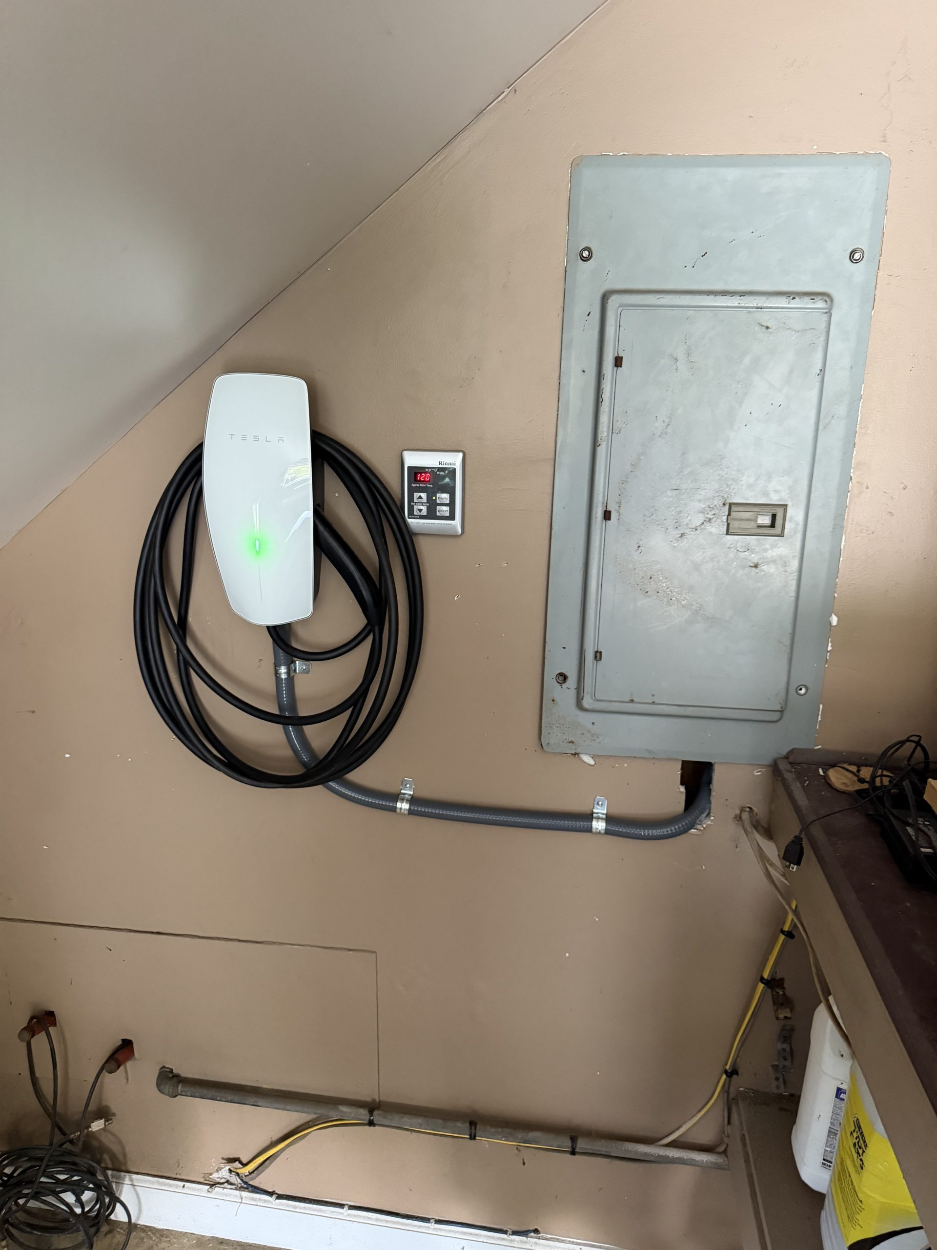 Tesla Level 2 EV Wall Connector installed alongside electrical subpanel by Wavecrest Electric