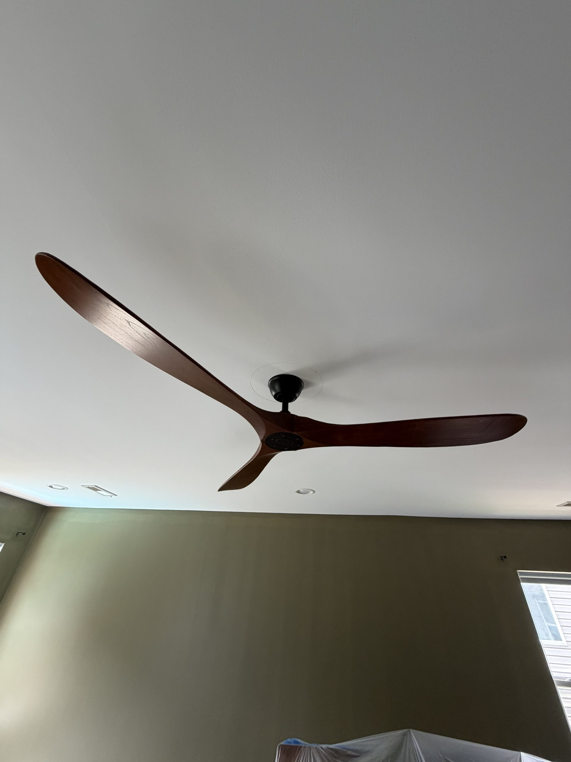 Sculpted 3-blade solid walnut aerodynamic ceiling fan installed into high ceiling by Wavecrest Electric