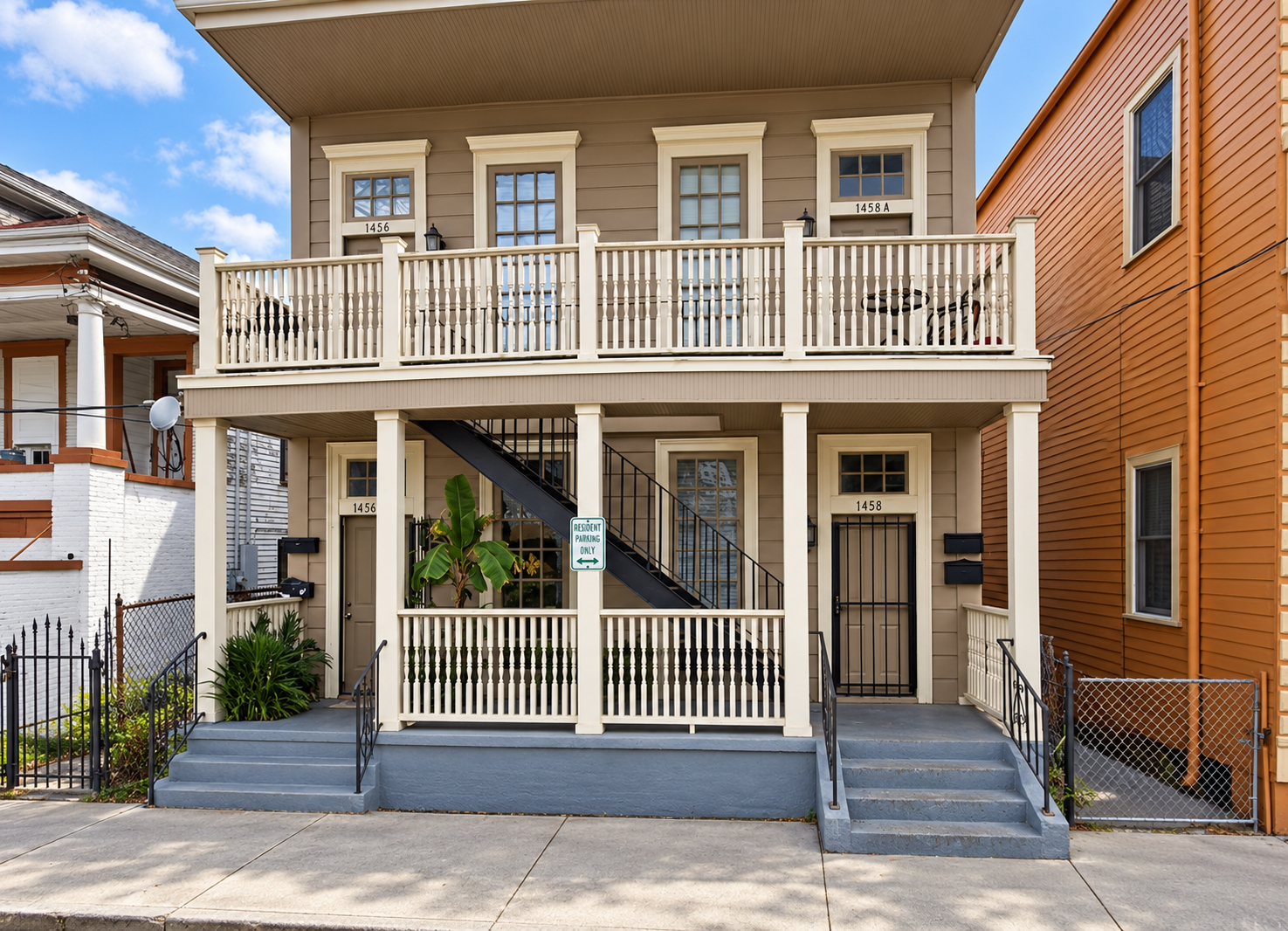 Historic two-story New Orleans property on Marais Street with covered double balconies, railed stair, and street-level entryways