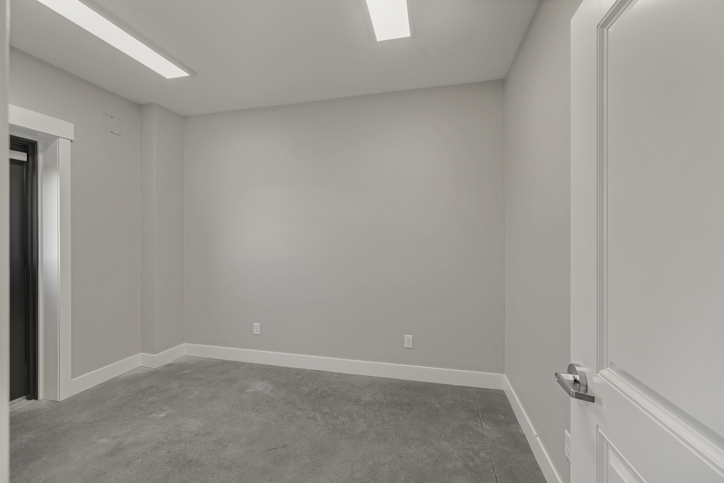 Private heated 10 x 12 office inside bay with neutral walls, trim, and sealed concrete flooring