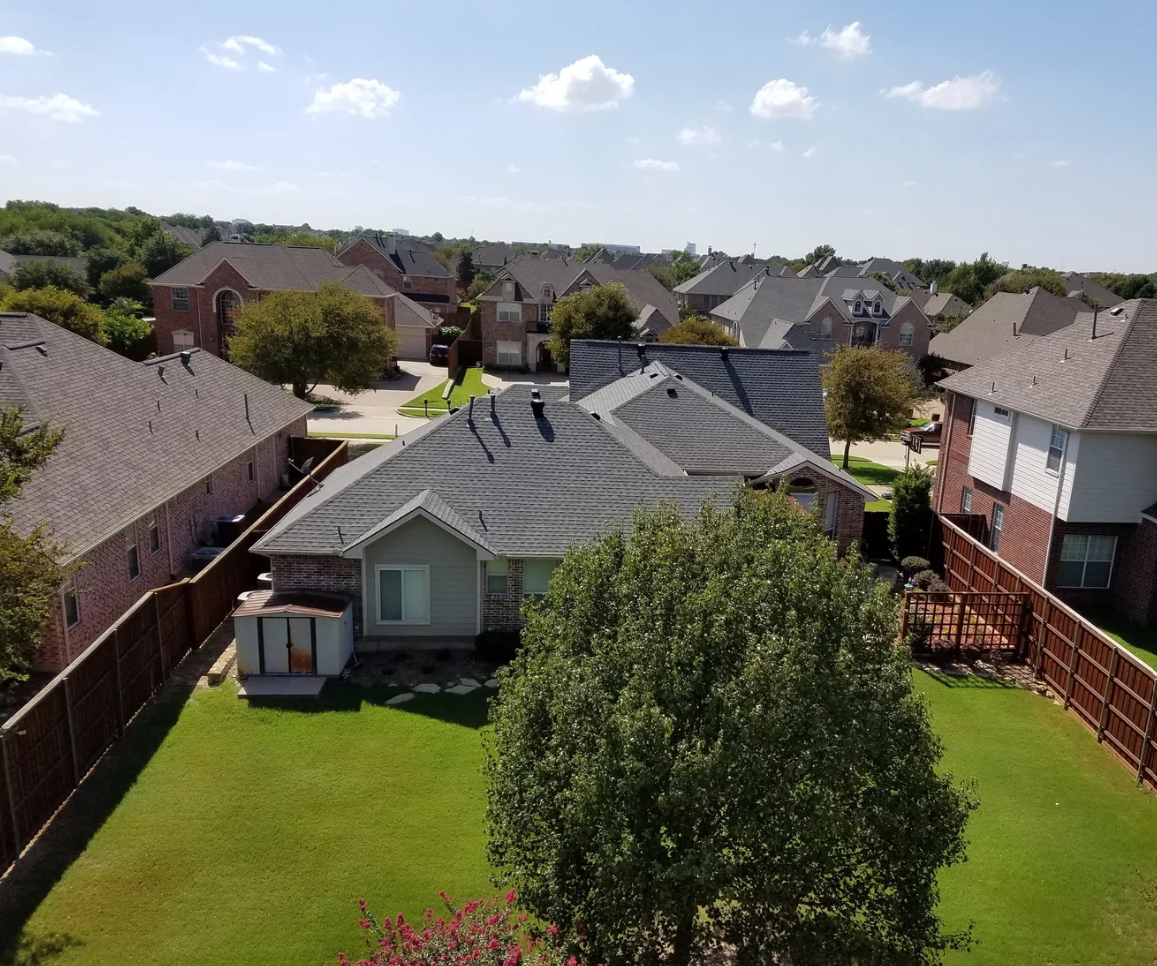 Aerial view of complete roof replacement and residential landscaping