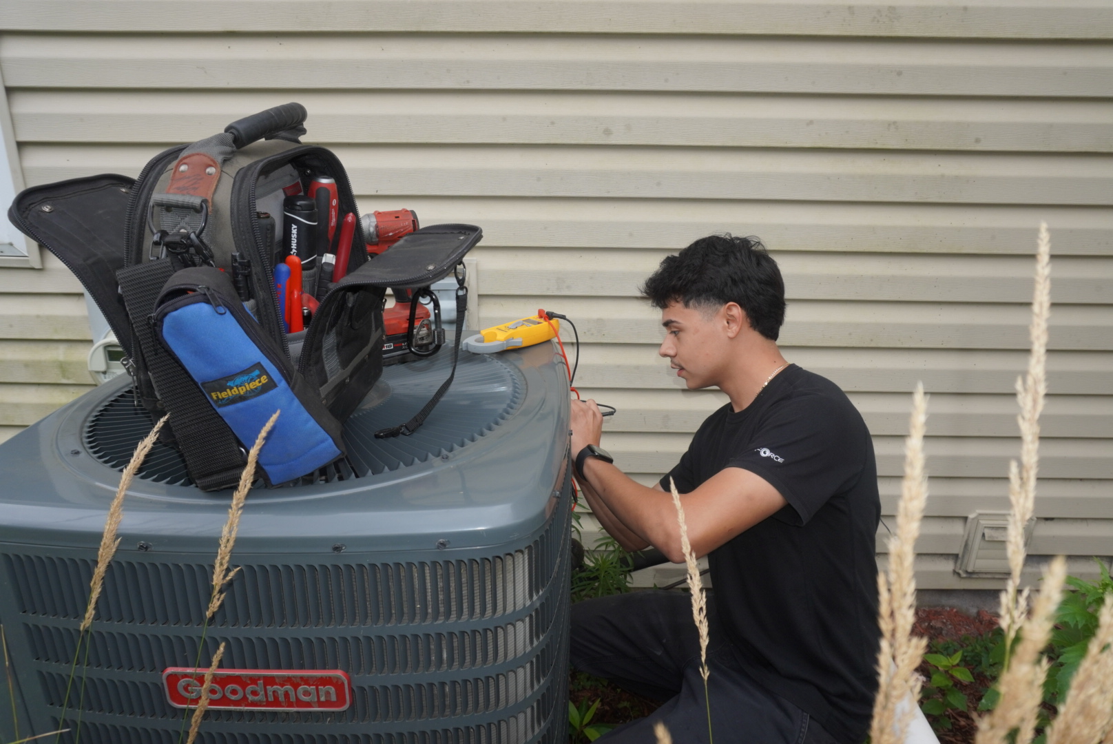 Leon, owner of Leon's Heating and Cooling LLC, servicing a residential outdoor AC condenser unit in Hanover Park, IL