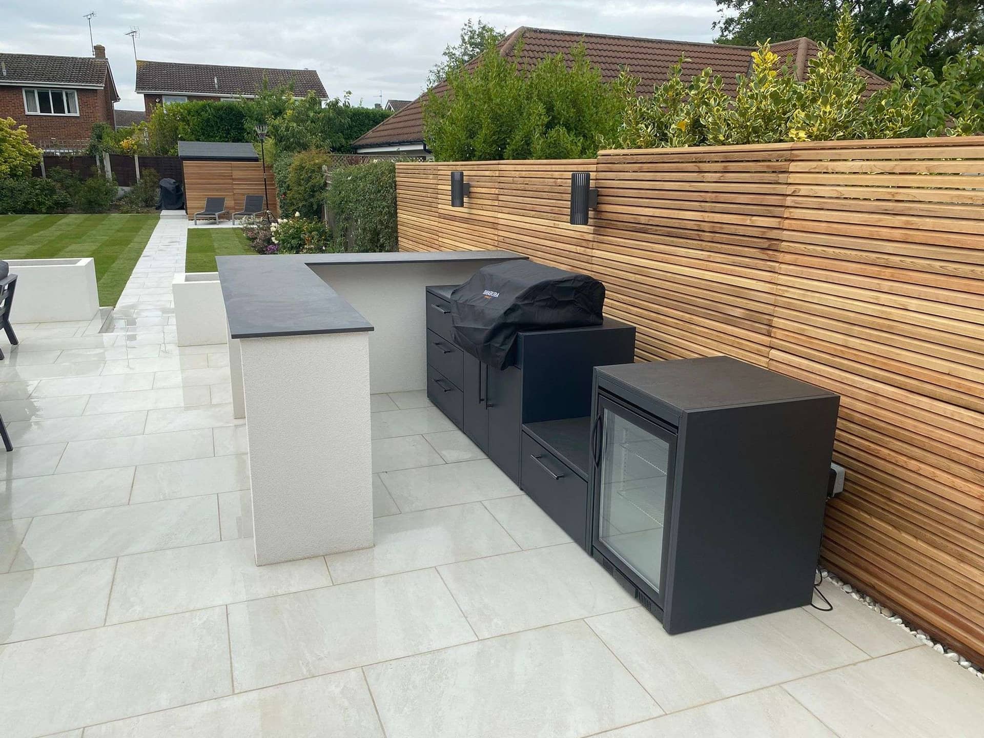 Outdoor bar structure with porcelain paving and timber cladding in Hadleigh garden