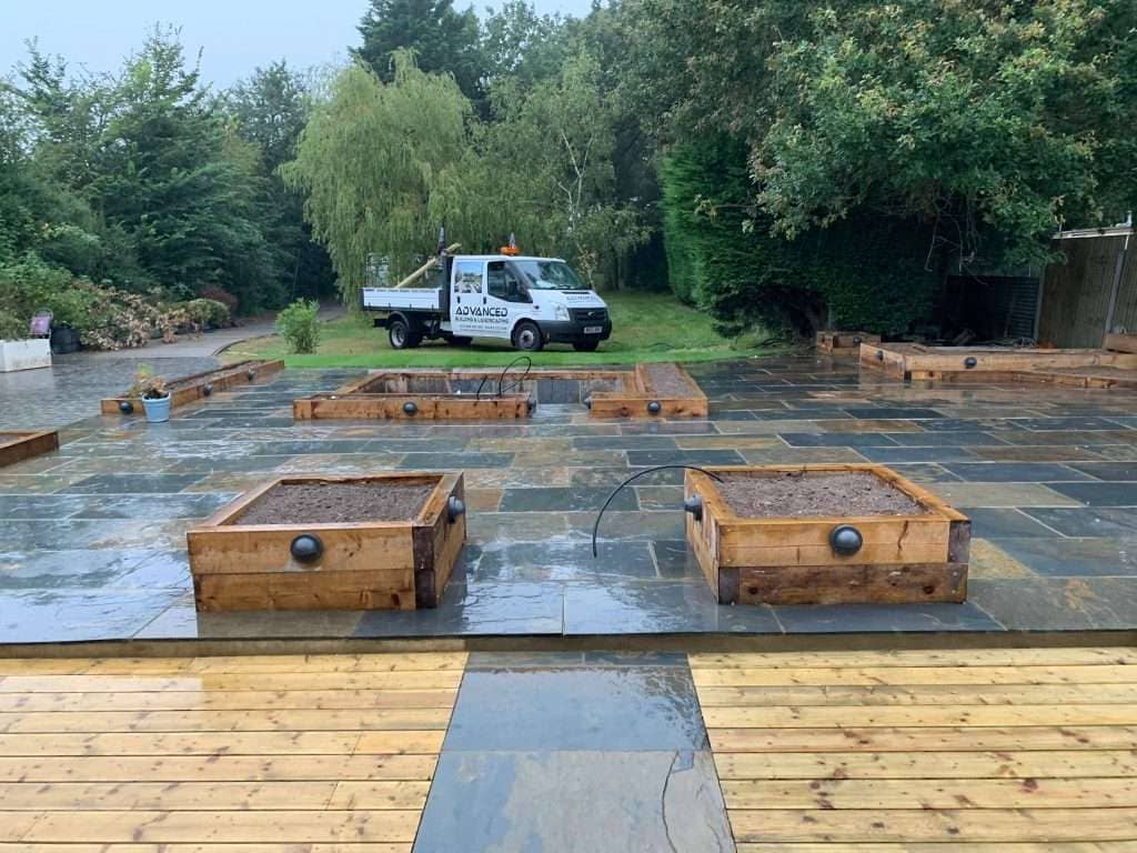 Raised timber planters and natural stone patio paving in Basildon