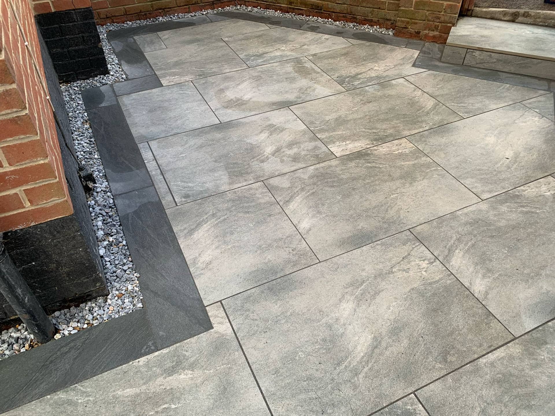 Detail view of porcelain paving corner with integrated channel drainage and sleeper edging