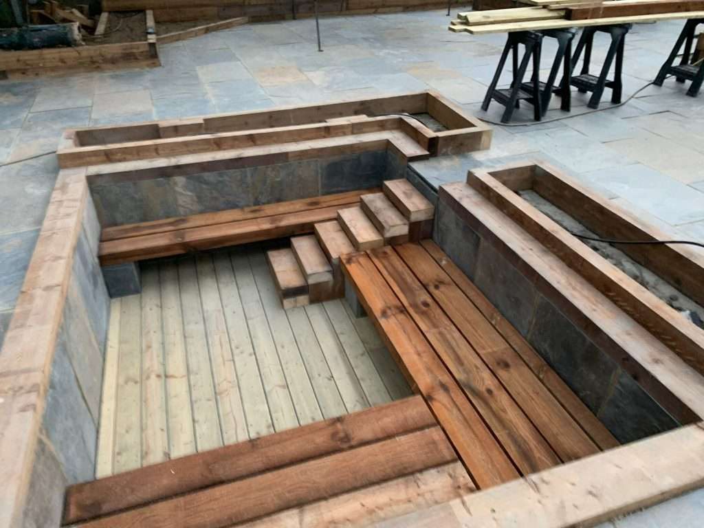 Timber seating and raised sleeper planters built in Basildon garden