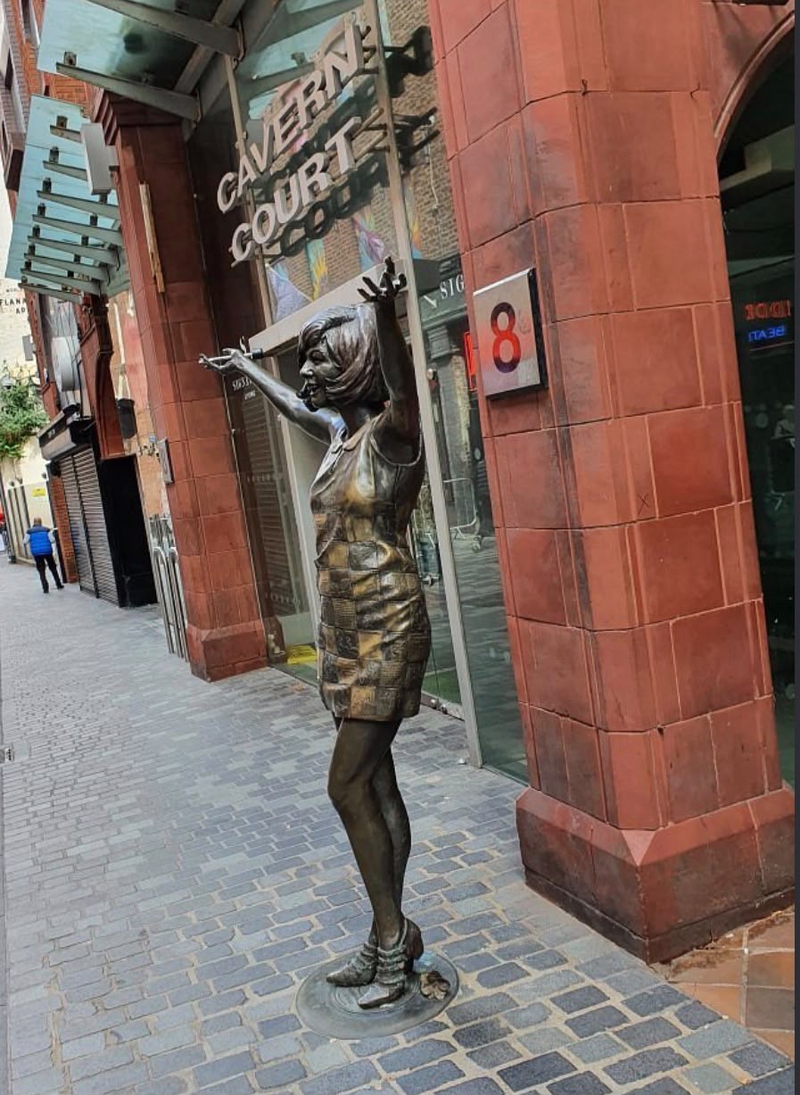 Cilla Black bronze statue outside Cavern Court on Mathew Street, Liverpool — the street-level source above the car park ingress