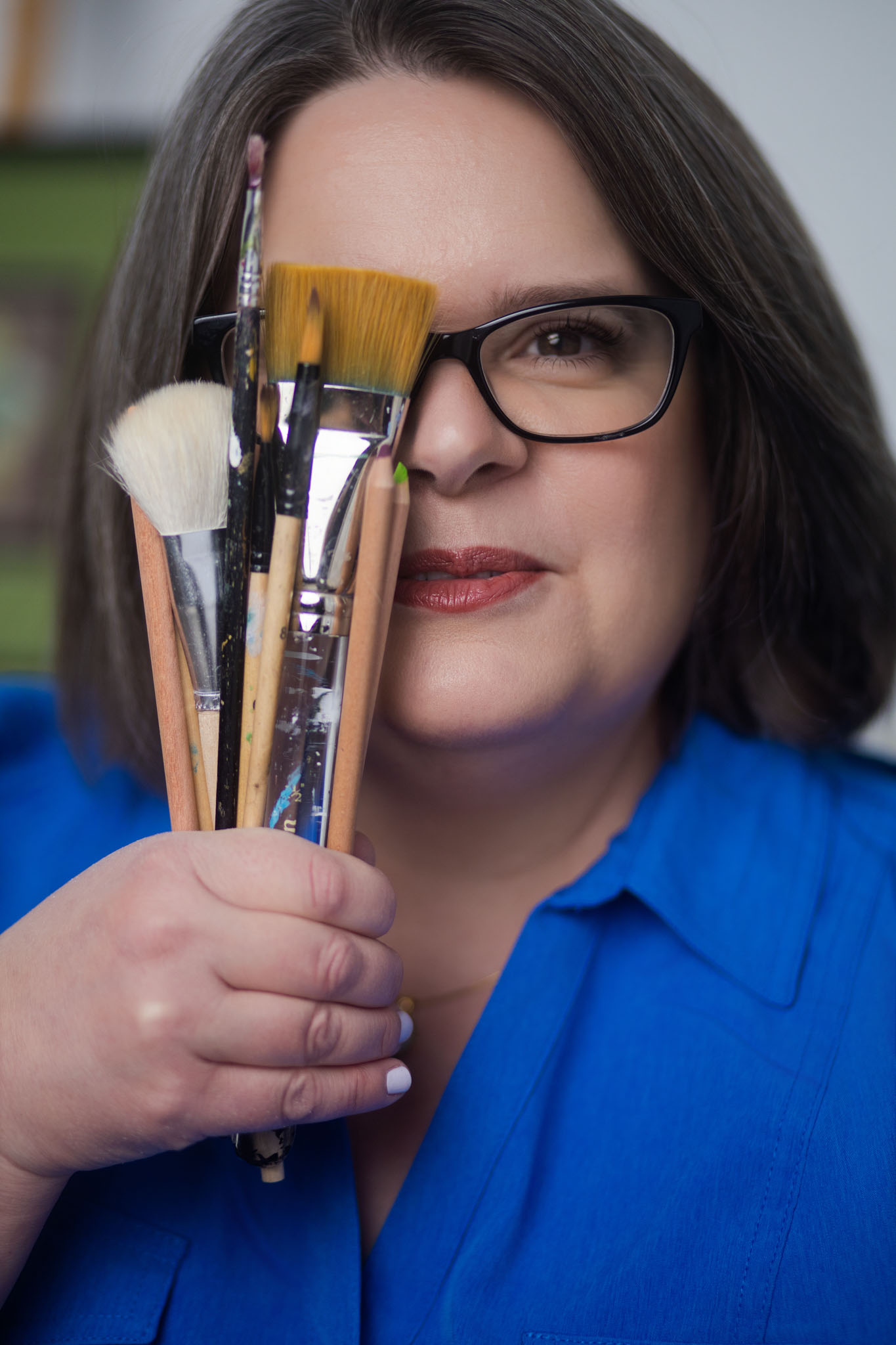 Laurie McAleenan holding her artist paintbrushes and tools