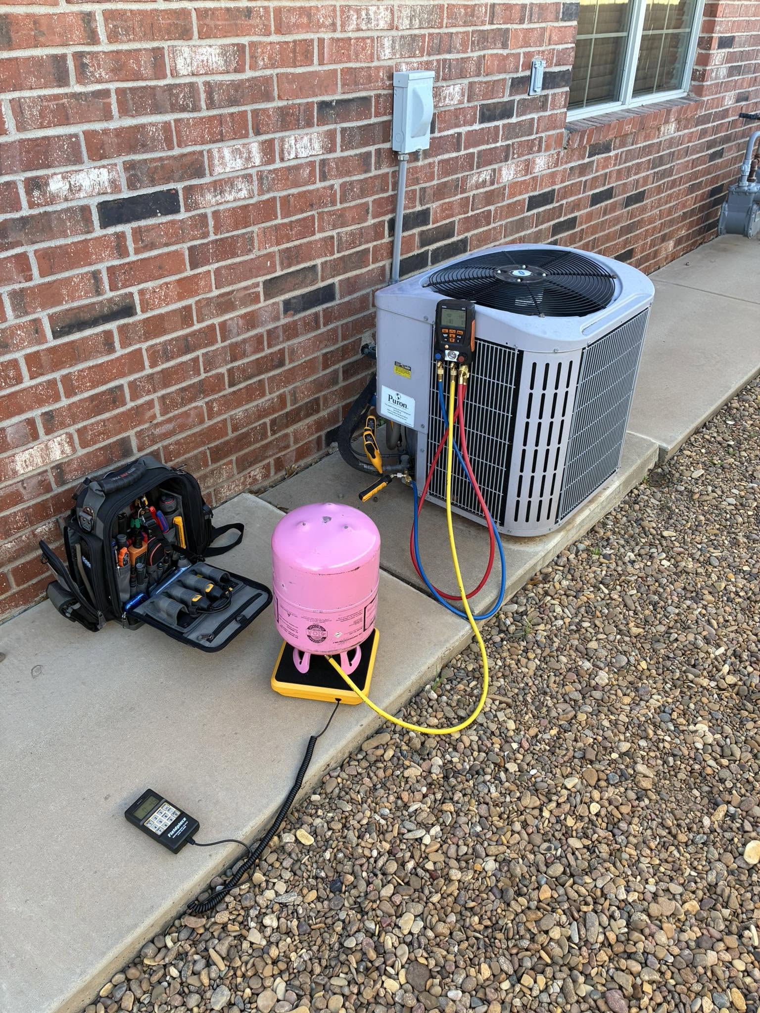 Patrick Heating & Air technician performing refrigerant diagnostics on a Carrier AC unit
