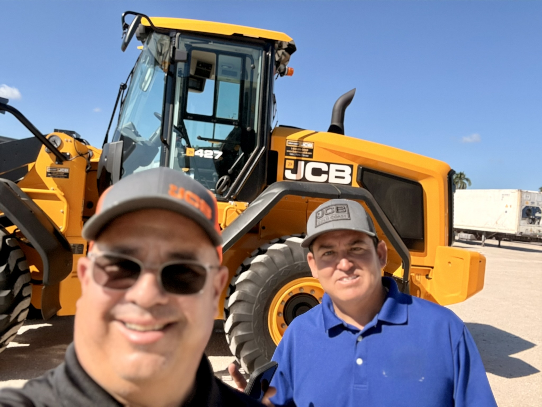 Jorge Menocal on-lot with a client beside a heavy JCB 427 wheel loader
