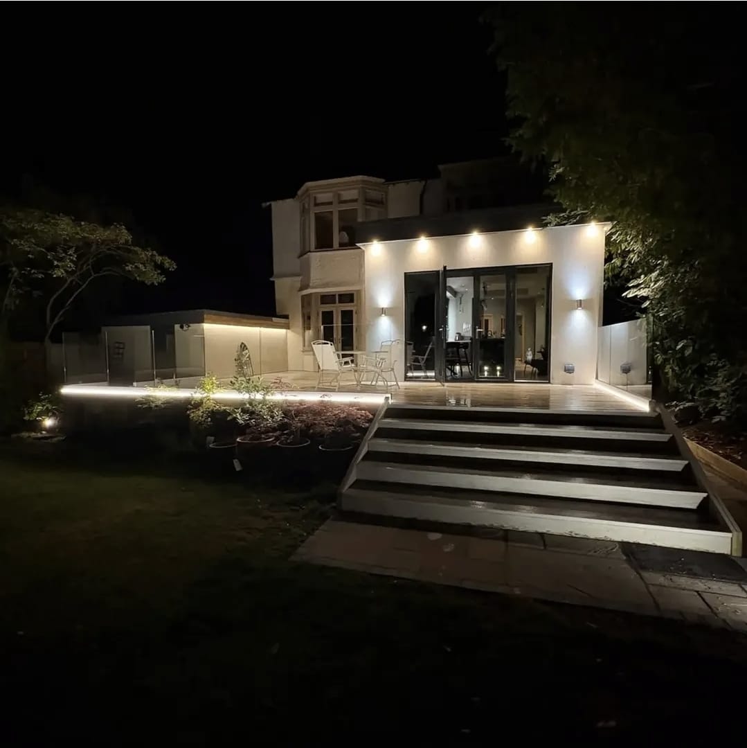 Full property exterior night view showing integrated architectural lighting