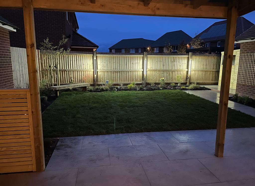 Covered patio garden canopy with perimeter fence lighting and lawn border illumination