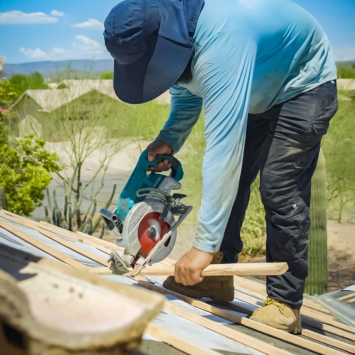 Roofer cutting battens with a circular saw