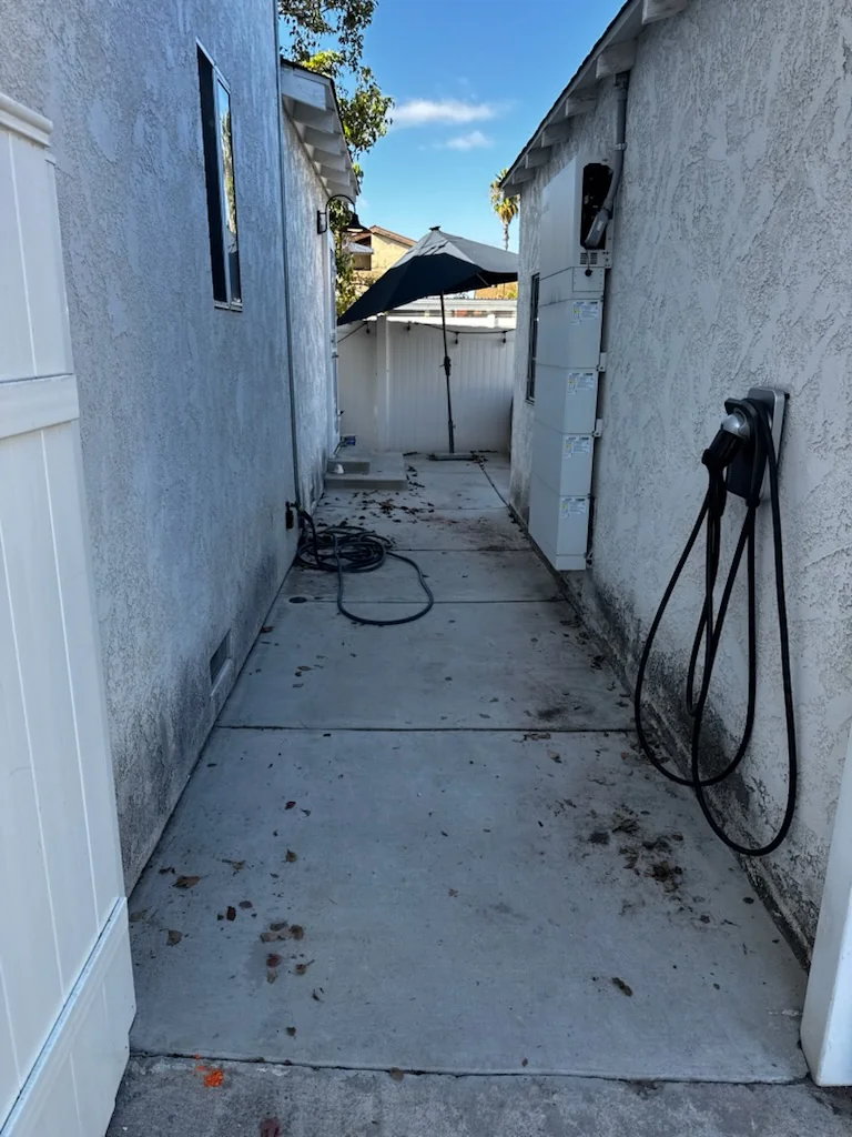 Cleared side walkway after sectional sofa, furniture, and trash removal in City Heights.