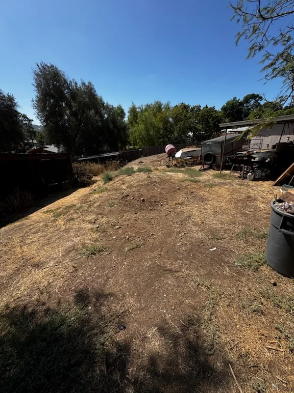Cleared yard area after demolition debris and trash removal at the Spring Valley property.